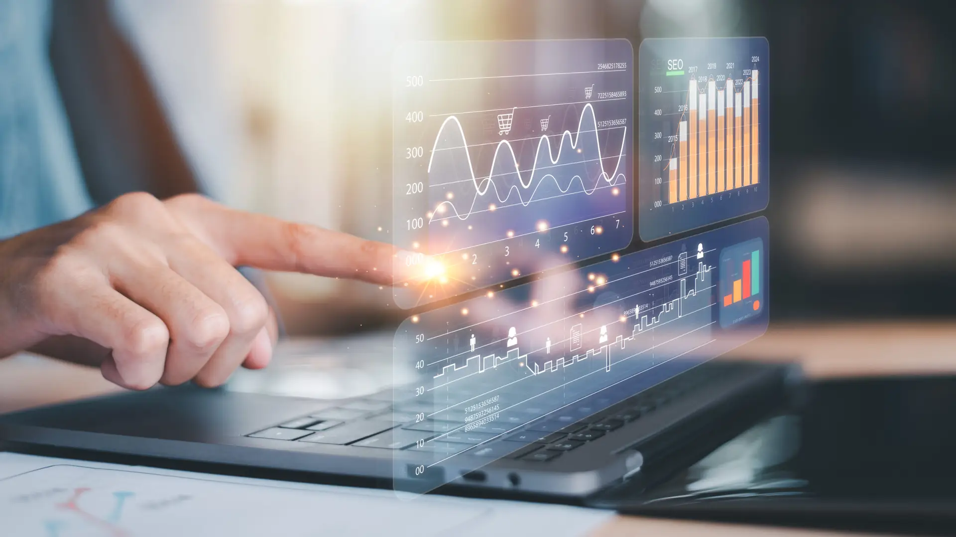 Naslovna Hand interacting with virtual analytics dashboard displaying SEO growth charts, data trends, and business performance metrics on laptop.